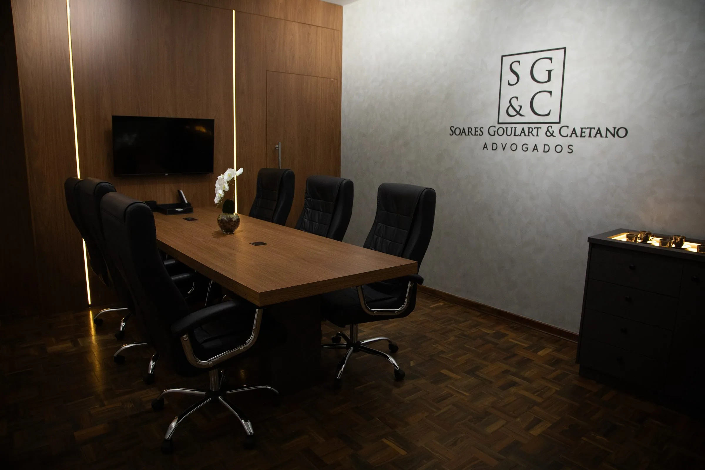 Sala de reunião com a marca SG&C na parede
